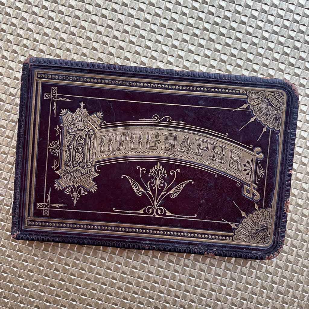 an 1800s Autograph Book against a gold background