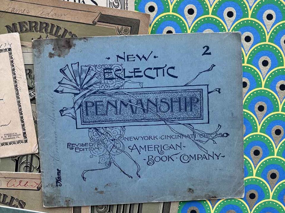 a stack of 1800s penmanship copy books