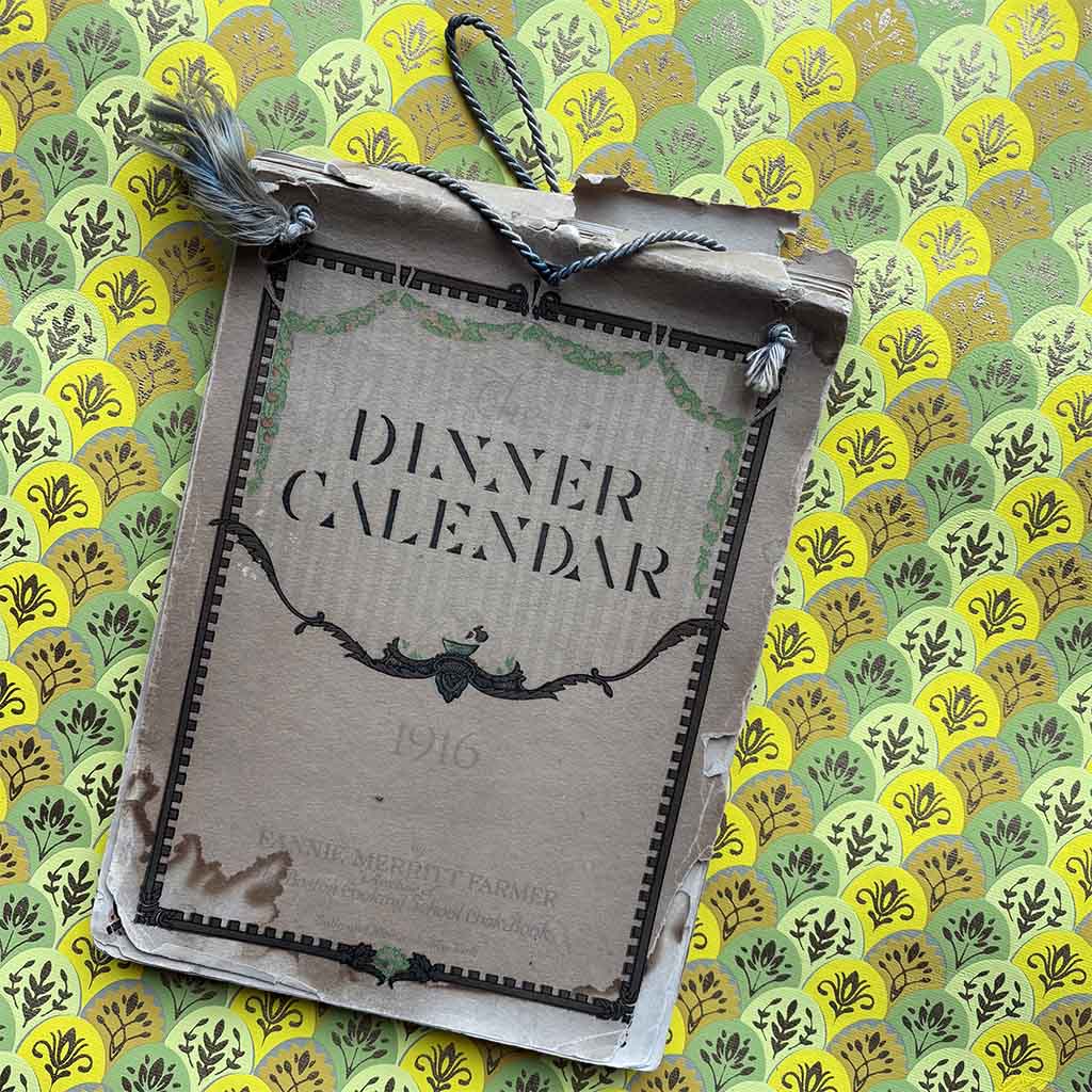 a 1916 Fannie Farmer Dinner Calendar against a brightly colored scalloped background